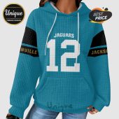Jacksonville Jaguars themed hoodie with the number 12 in white, set on a textured turquoise background.!