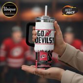 White travel mug featuring 'Go Devils!' and Carolina Hurricanes logos, hockey sticks graphic elements.!
