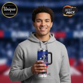 Man holds a 30oz travel tumbler with straw and handle featuring a cartoon sports design and the text: 'Let's Go Plunthers Plunther'!