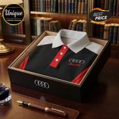 Audi polo shirt with logo in a wooden box on a desk with a pen.!