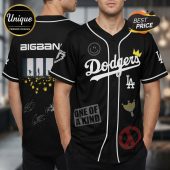 Black baseball jersey with BIGBANG graphic, 'Dodgers' text, smiley face, crowns, peace sign. Edgy K-Pop fashion!
