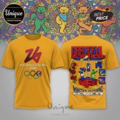 Gold tee with Grateful Dead 2026 Winter Olympics mashup design! Text reads: Milano Cortina 2026, Grateful Dead, Winter Olympic Games!