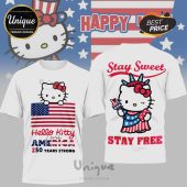 White tee w/ Hello Kitty, US flag design. Text: Hello Kitty loves AMERICA 250 YEARS STRONG, Stay Sweet, Stay Free. Red, white, blue!