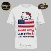 White tee with Hello Kitty, US flag art. Text: Hello Kitty loves America, 250 Years Strong. Red, white, blue colors!