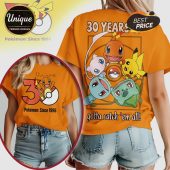 Orange tee: 30 Years Pokemon. Cartoon style: Charmander, Pikachu, Squirtle, Bulbasaur, Mew. 'Gotta catch 'em all!' text!