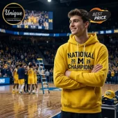 Yellow hoodie with black text 'NATIONAL 20 M 26 CHAMPIONS 2026 NCAA MEN'S BASKETBALL CHAMPIONSHIP' college sports apparel!