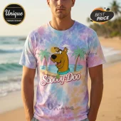 Pastel tie-dye t-shirt featuring a cartoon Scooby-Doo graphic with palm trees and sun on a beach background!