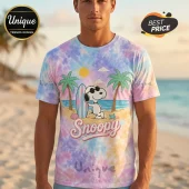 Tie-dye t-shirt featuring Snoopy with a surfboard on a beach with palms and the text Snoopy in a retro font!