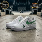 Custom white sneakers with green swoosh, Man in the Arena Tour text, and script graphics on a concrete floor background!