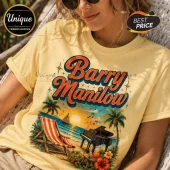 Woman wearing a yellow t-shirt with a vintage Barry Manilow graphic, beach scene, grand piano, and sunset illustration.!