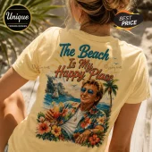 Woman wearing a pastel yellow t-shirt with a vintage-style tropical graphic of a man holding a cocktail on a beach.!
