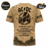 Tan AC/DC graphic t-shirt featuring a cannon, lightning bolt, and lyrics printed in black on an all-over textured pattern.!