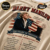 Barry Manilow graphic t-shirt in beige cotton featuring a US flag, piano, fireworks, and song titles in vintage red and blue.!