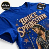 Blue cotton t-shirt featuring a vintage Bruce Springsteen graphic with stars, fireworks, and text in tan and red print.!