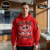 Man wearing a red Carolina Hurricanes 2026 Stanley Cup Champions hoodie with a trophy graphic in the center.!