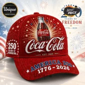Red Coca-Cola baseball cap featuring a glass bottle, fireworks graphics, and 1776-2026 America 250 anniversary text.!