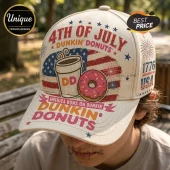 Off-white baseball cap featuring 4th of July Dunkin Donuts text, a coffee cup, pink donut, and American flag graphics.!