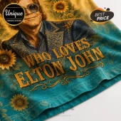 Elton John graphic t-shirt featuring sunflower patterns on teal fabric with gold text reading Who Loves Elton John.!