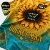 T-shirt with sunflower design, reading Flying high beyond the stars and ROCKET MAN in gold text on yellow-blue gradient.!