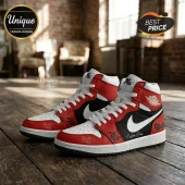 Custom Nike Air Jordan 1 high-top sneakers in red, black, and white leather with graffiti-style text on a wooden floor.!