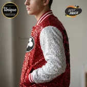 Profile view of a person wearing a red sequined varsity jacket with silver sleeves and striped ribbed collar and cuffs.!
