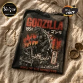 Black vintage-wash t-shirt featuring a Godzilla 1954 graphic with red, orange, and black kaiju artwork on beige fabric.!