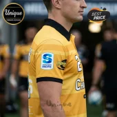 Yellow Hurricanes Super Rugby Pacific polo shirt with black collar and team logos worn by a male athlete.!