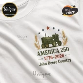 White cotton t-shirt featuring a green John Deere tractor graphic with wheat stalks, stars, and America 250 text.!