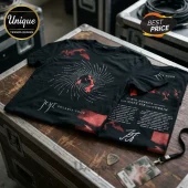 Joji Solaris Tour black graphic t-shirt with red spiral design, tour dates, and artist branding on a wooden crate surface.!