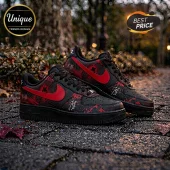 Black Nike Air Force 1 sneakers with red swoosh, red splatter pattern, and Joji musician branding on a stone pathway.!