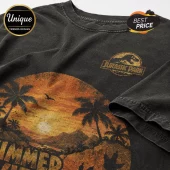Black vintage-wash cotton t-shirt featuring a Jurassic Park logo and a sunset palm tree tropical graphic print.!