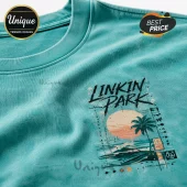 Teal t-shirt featuring Linkin Park graphic with a palm tree, sunset, and grid patterns in black, orange, and tan ink.!