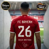 Man wearing red FC Bayern jersey number 26 with Colin Brittain name and autograph, set in a stadium tunnel background.!