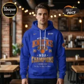 Blue New York Knicks 2025-26 NBA Champions hooded sweatshirt featuring orange lettering and basketball graphic on front.!