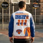 New York Knicks varsity jacket featuring orange and blue text, championship trophy graphics, and skyline art on white back.!