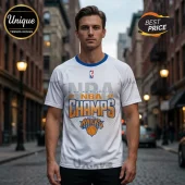 Man wearing white New York Knicks 2026 NBA Champs graphic t-shirt with blue crew neck and central basketball logo design.!
