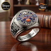 New York Knicks 2026 NBA championship ring with silver band, blue enamel, embedded crystals, and team logo on wood table.!