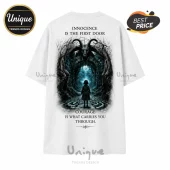 White t-shirt featuring a dark fantasy print of a child facing a goat-headed gate with text above and below the graphic.!