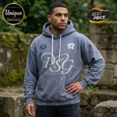 Man wearing a slate grey PSG hooded sweatshirt with white distressed script logo, white drawstrings, and club crest patch.!