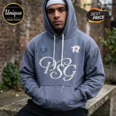 Man wearing a blue pullover hoodie with white PSG calligraphy, a Paris Saint-Germain crest, and a white beanie.!