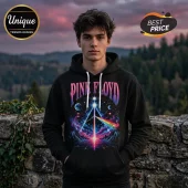 Man wearing black hoodie with Pink Floyd prism graphic, neon colors, star field, and white drawstrings, outdoor background.!