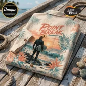 Beige button-down shirt with Point Break sunset surf graphic, tropical leaf patterns, and dark brown buttons on wood deck.!