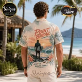 Man wearing a tan short-sleeve button-down shirt featuring a sunset beach graphic, a surfer, and Point Break text.!