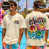 Cream-colored t-shirt featuring M&M characters wearing sunglasses and floating in pool tubes with a summer pool party theme.!