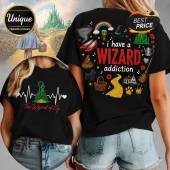 Black t-shirt featuring Wizard of Oz graphics including ruby slippers, yellow brick road, emerald city, and text.!