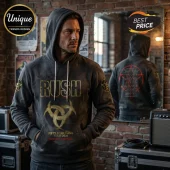 Man wearing grey Rush band hoodie with gold logo and Fifty Something Tour 2026 text against a brick wall studio background.!