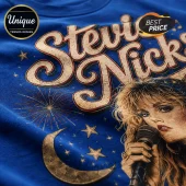Blue t-shirt featuring a vintage-style graphic of Stevie Nicks with gold stars, a crescent moon, and fireworks.!