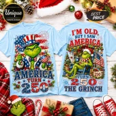Light blue t-shirts featuring The Grinch with American flag motifs and text reading America Turn 250 and I am old.!