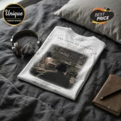 White cotton t-shirt featuring The Lives of Others film graphic, surveillance imagery, and text on a grey textured bed.!