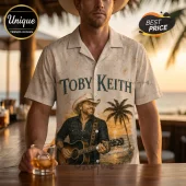 Cream-colored button-down shirt featuring a beach theme, a graphic of Toby Keith with a guitar, and nautical shell print.!